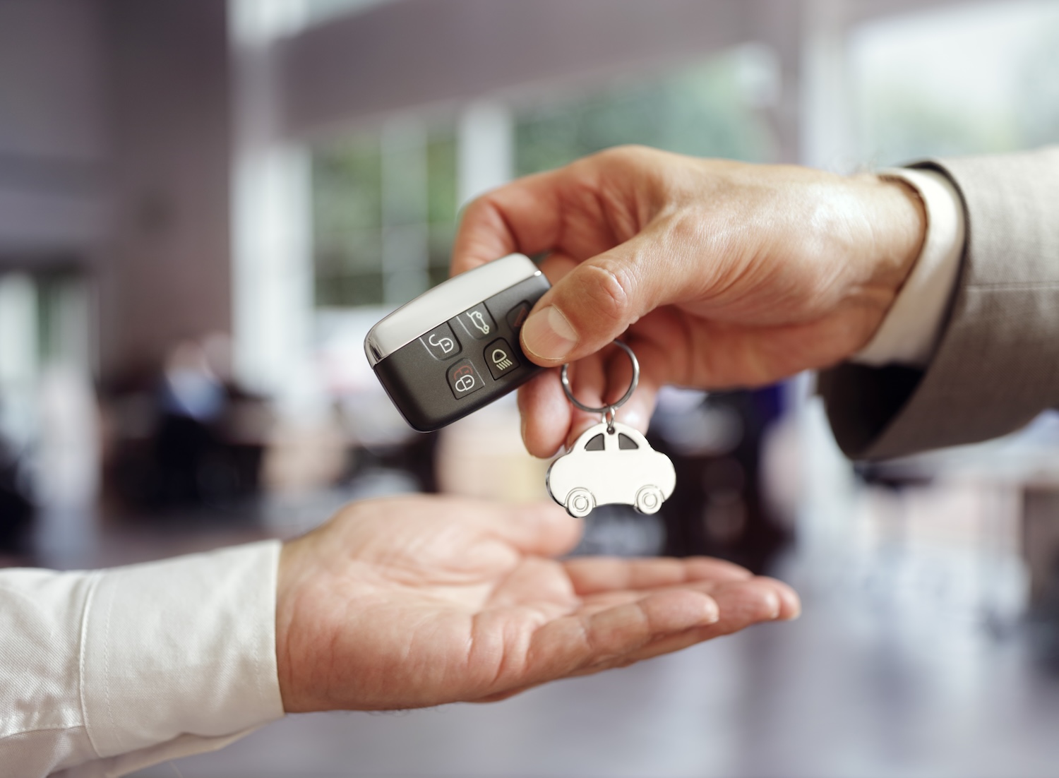 Finor Finance Close up to hand of a man giving car keys to another man